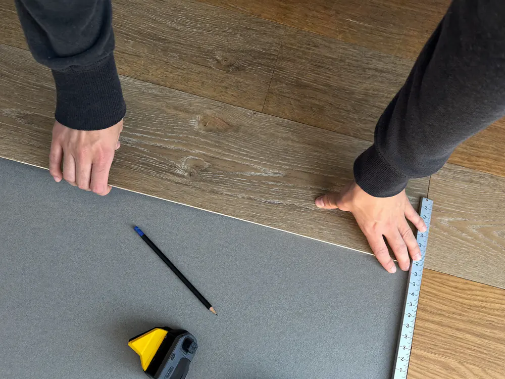 Klik-PVC plank wordt aangelegd op een grijze ondervloer
