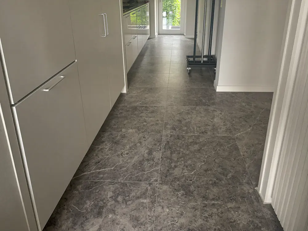 PVC tegels in grijze marmerlook in de hal en keuken van een appartement